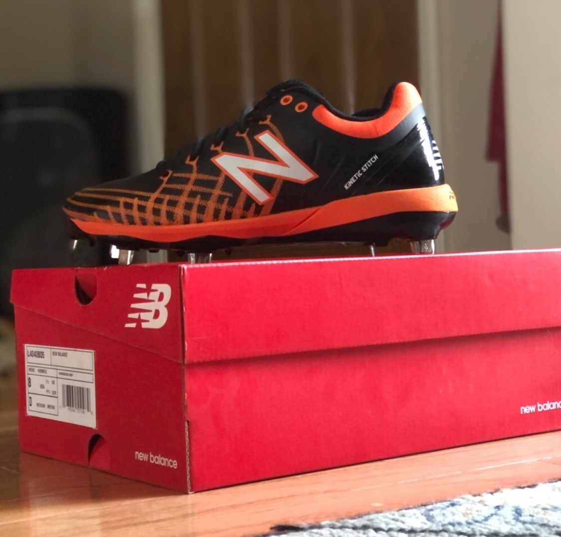 black and orange new balance cleats