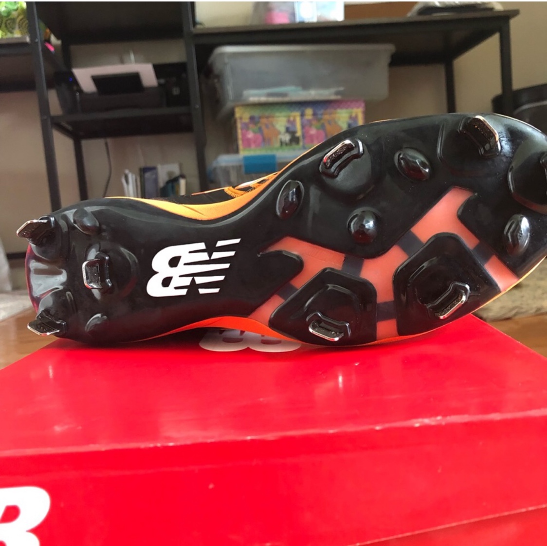 black and orange new balance cleats